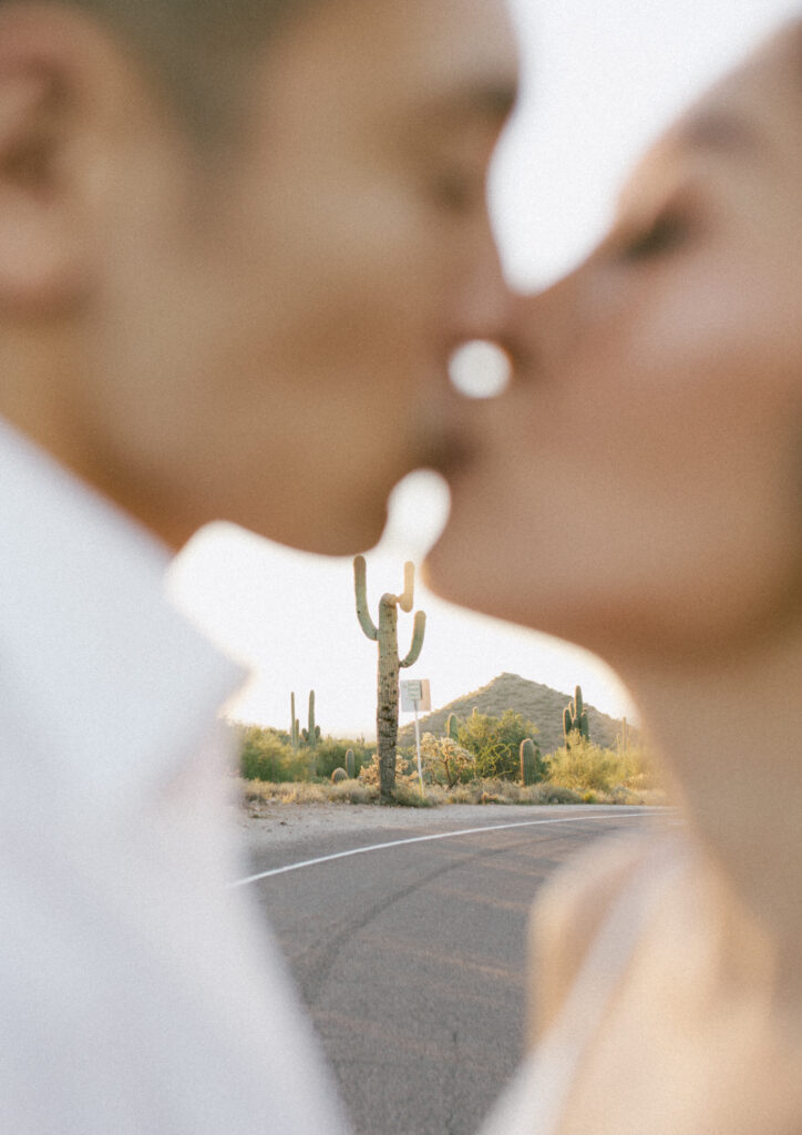 J and Alice intentionally out of focus Arizona Sunrise Engagement Session sharing a tender kiss