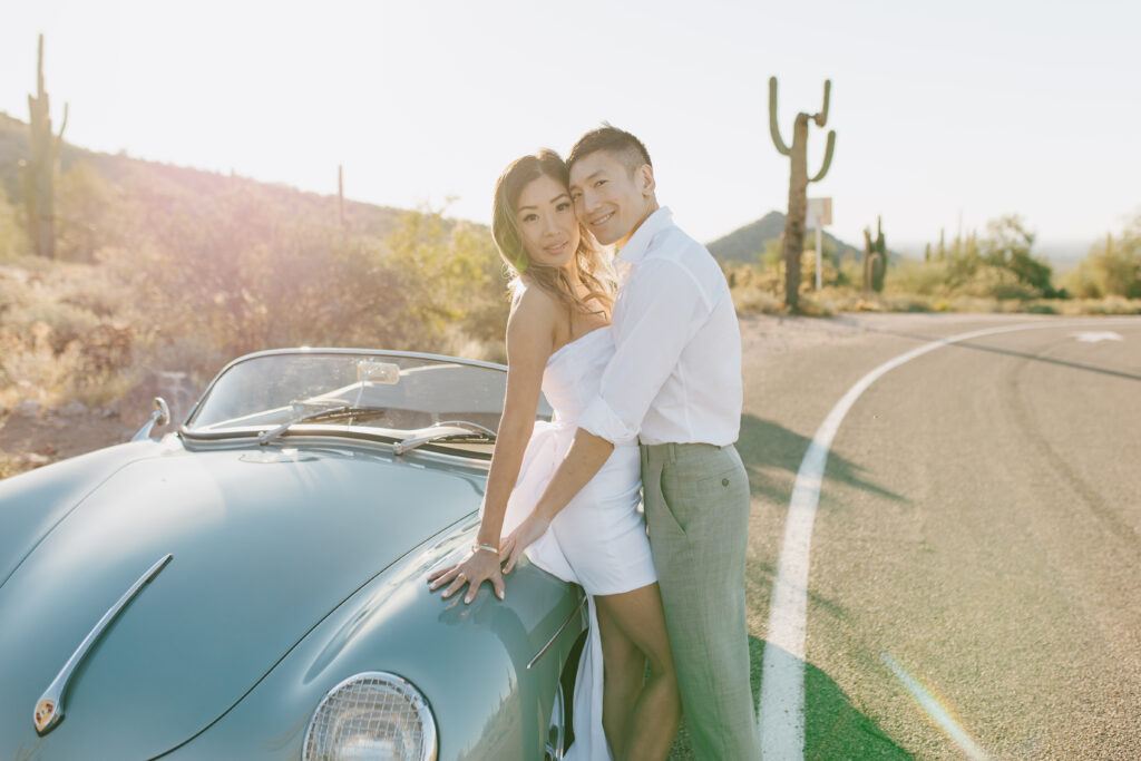 J and Alice's Blue Classic Car Arizona sunrise Engagement Session. J & A leaning against the car