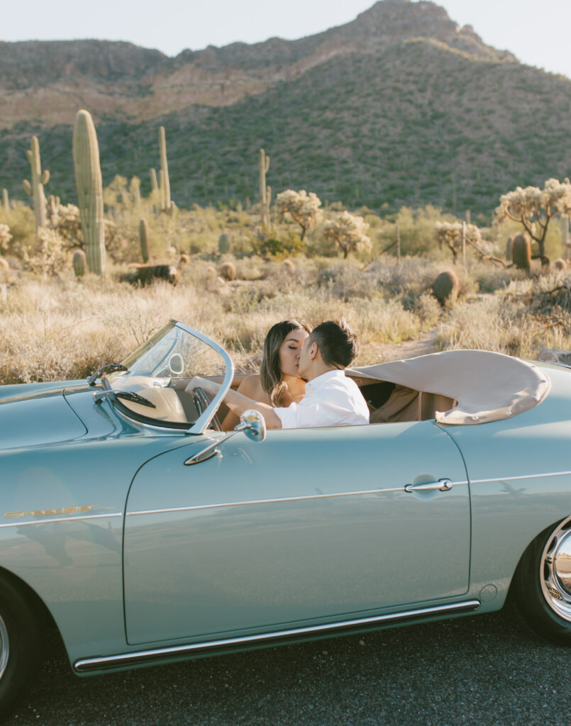 J and Alice's Blue Classic Car Arizona sunrise Engagement Session. J & A sharing a kiss in the front seat