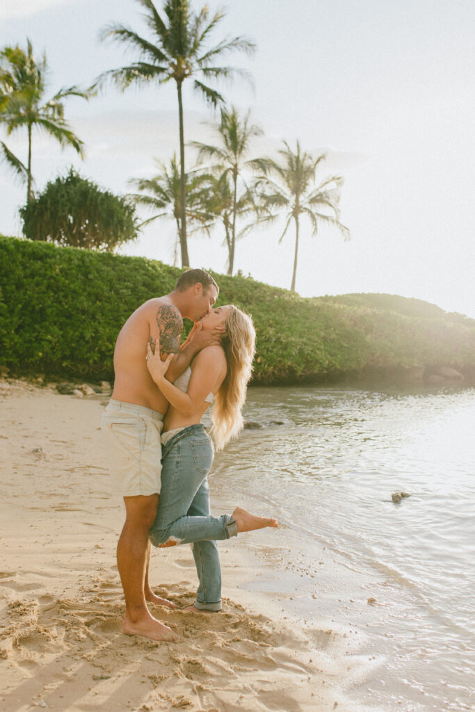 Gabby and Kyle at Oahu sunset nearly in their swim suits sharing a kiss, Beach Engagement Session, Hawaii Engagement Photographer, Destination Engagement Photographer