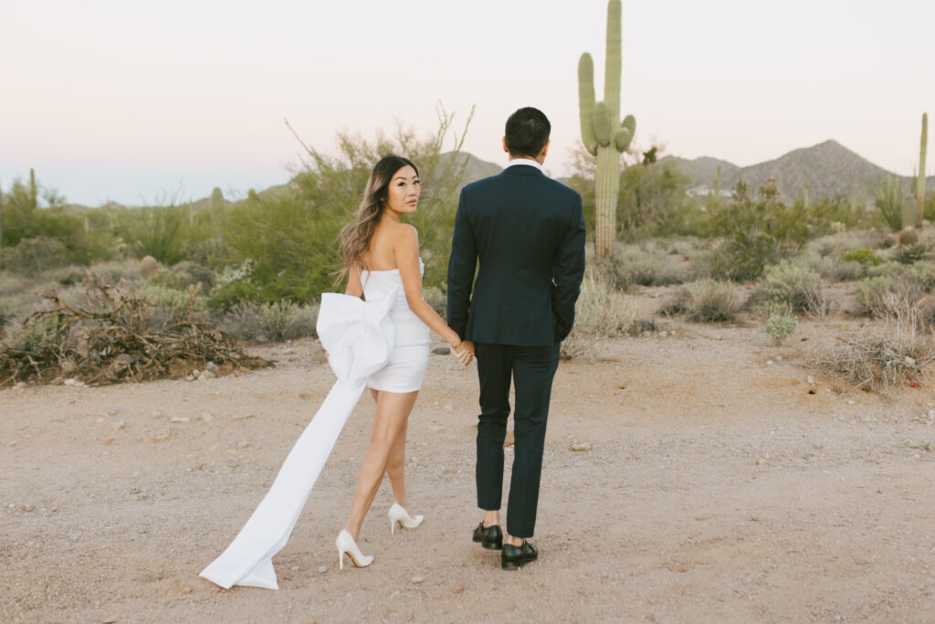 J and Alice’s Arizona Engagement Session walking hand in hand in the desert formal attire