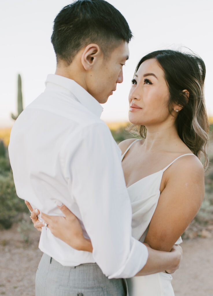 J and Alice's Arizona Sunrise Engagement Session sharing a gentle embrace with soft smiles