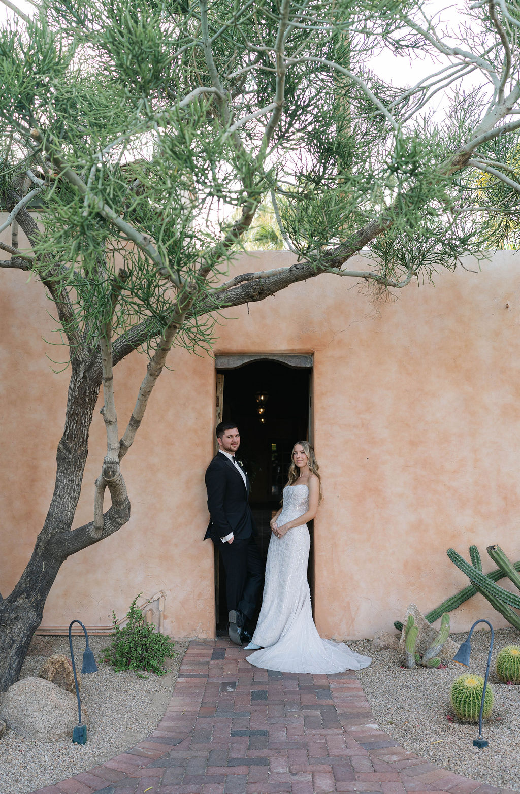 Bride and groom stand smiling at the camera during their wedding day at Royal Palms in Scottsdale, Arizona, Photographed by Jaidyn Michele.