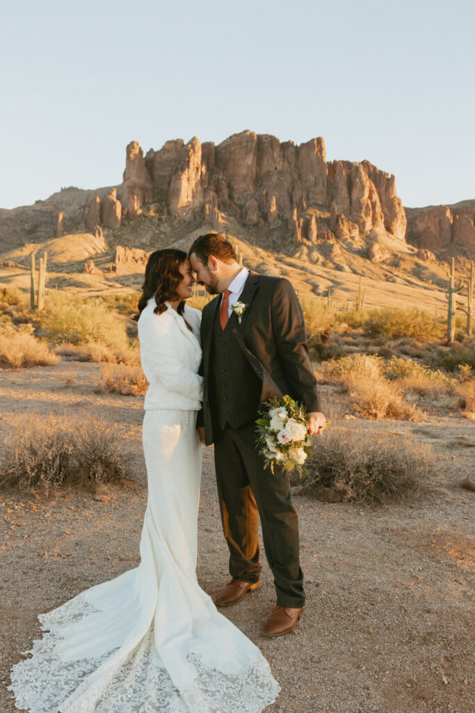 Husband and Wife take photos at The Superstition Mountains inside Lost Dutchman State Park on their wedding day.