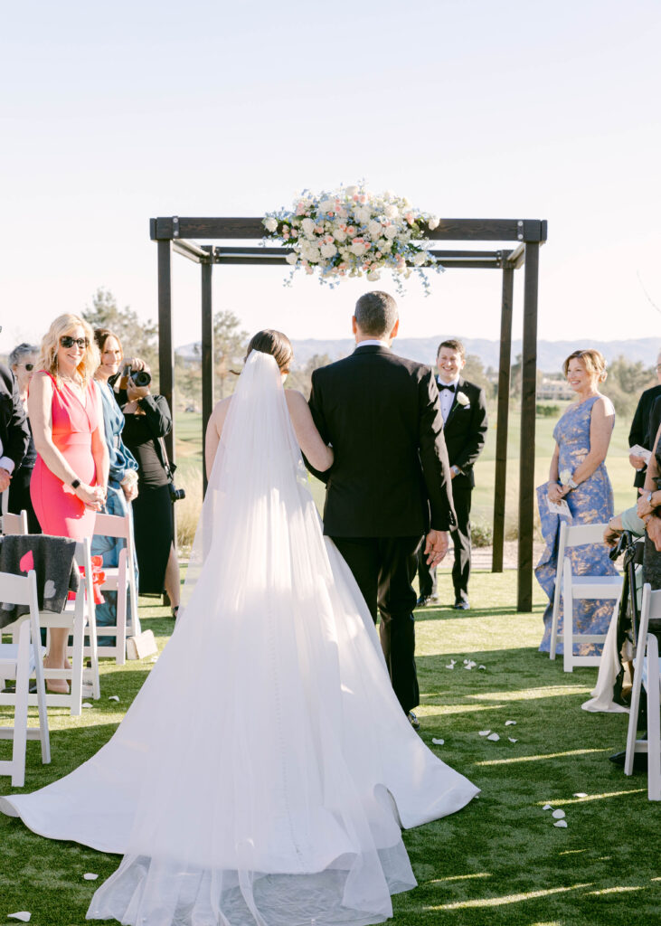 Wedding ceremony taking place on the lush green lawn of Arizona Biltmore Golf Club.