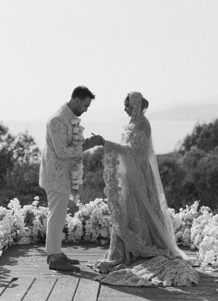 Elegant multi-cultural bride and groom sharing a romantic moment during their destination wedding ceremony in Santa Barbara, with breathtaking coastal views and luxurious details.