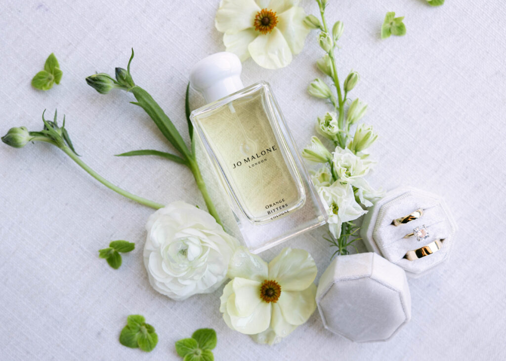 Bridal flat lay with florals, perfume, and heirlooms styled for what to pack for your wedding detail photos.